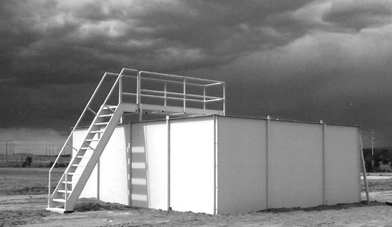 Modular MOBILE Shoothouse set up on level ground at a military tactical training facility black and white